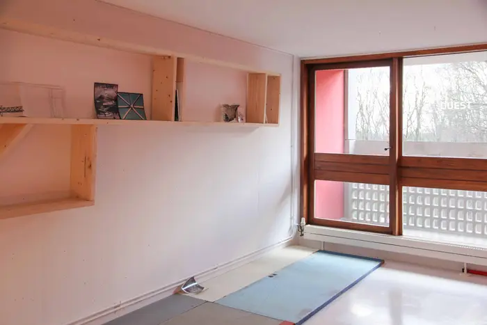 Ein leeres Zimmer mit einem großen quadratischen Fenster