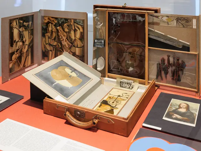 In einem Schaukasten sind ein geöffneter Koffer und mehrere Zeichnungen ausgestellt.