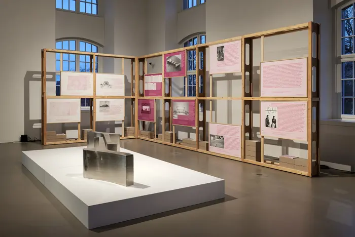 Ausstellungsraum mit Holzregalen.