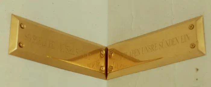 goldenes Schild im rechten Winkel an einer Ecke montiert