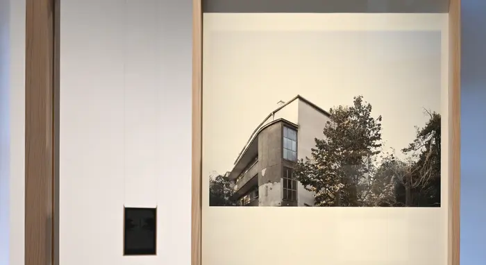 Die Fotografie einer Häuserecke mit Baum.