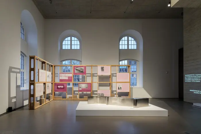 Ausstellungsraum mit Holzregalen.