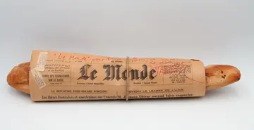 Ein in eine Zeitung gewickeltes Baguette.
