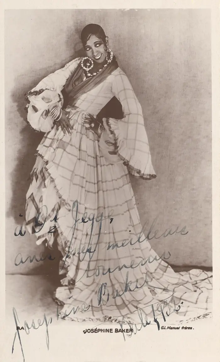 Eine schwarze Frau posiert in einem schicken Kleid. 