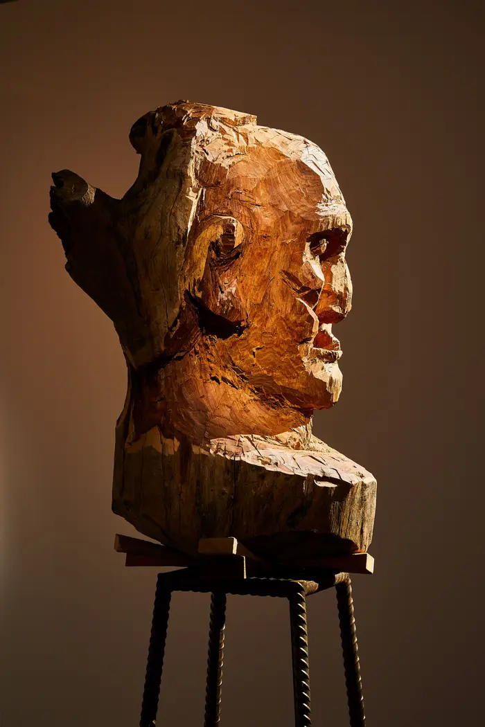 Holzskulptur eines Kopfes von der Seite