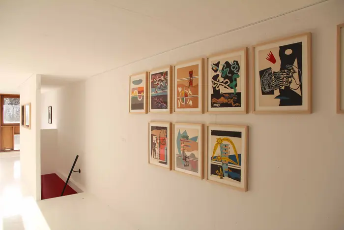 Eine Wand mit acht abstrakten Bildern 