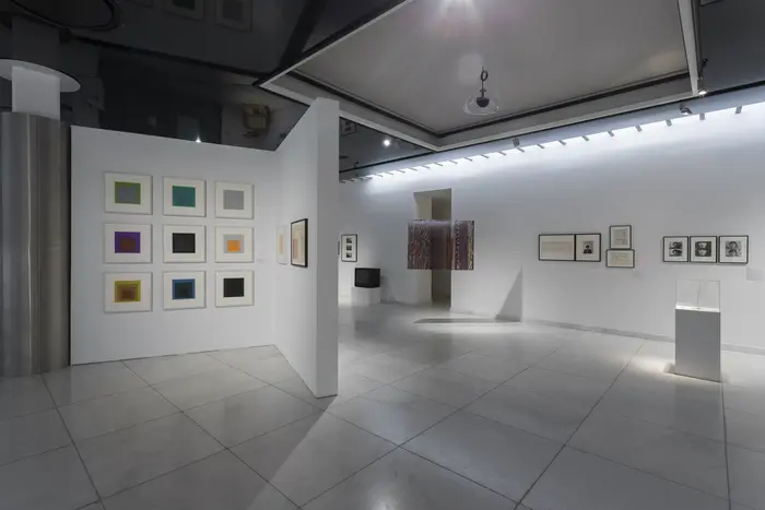 Eine Ausstellungsansicht mit an den Wänden hängenden Bildern. 