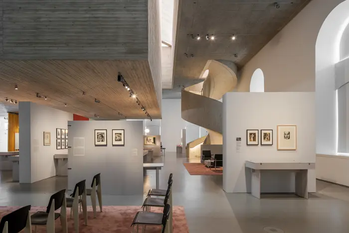 Ein grauer Ausstellungsraum mit Teppichen.